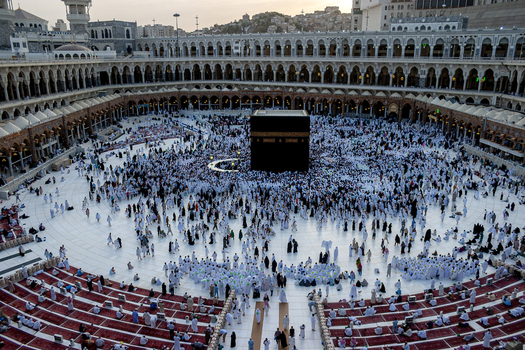 Aerial view of Masjid al Haram with the Kaaba surrounded by large crowds of pilgrims in white clothing in the courtyard in Makkah Makkah Province Saudi Arabia. Aerial view of Masjid al Haram with the Kaaba surrounded by large crowds of pilgrims in white clothing in the courtyard in Makkah Makkah Province Saudi Arabia.