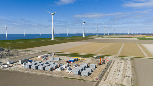 Espel Netherlands 04 April 2026 Aerial view of the Westermeerdijk wind farm and a battery energy storage system facility situated next to agricultural fields under a clear blue sky.