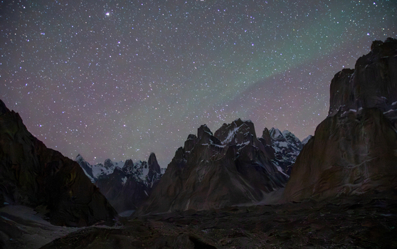View of Trango Towers in the Karakoram mountain range under a starry night sky with faint aurora borealis in Ghakhar Punjab Pakistan. View of Trango Towers in the Karakoram mountain range under a starry night sky with faint aurora borealis in Ghakhar Punjab Pakistan.