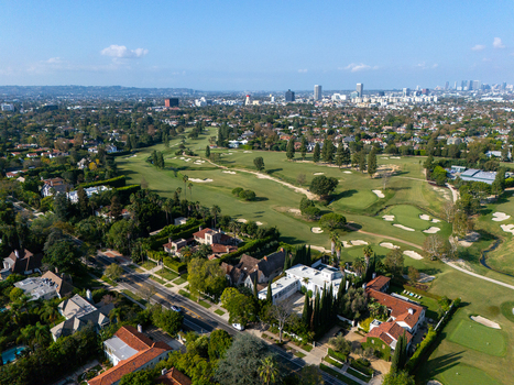 Aerial view of Wilshire Country Club with lush green fairways sand bunkers and residential neighborhoods near the city skyline in Los Angeles California United States. Aerial view of Wilshire Country Club with lush green fairways sand bunkers and residential neighborhoods near the city skyline in Los Angeles California United States.