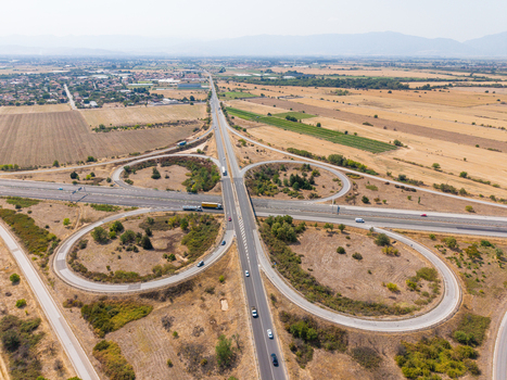 Aerial view of Highway Trakiya interchange surrounded by dry agricultural fields and rural landscape in Bulgaria. Aerial view of Highway Trakiya interchange surrounded by dry agricultural fields and rural landscape in Bulgaria.