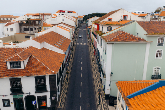Aerial view of a quiet street lined with traditional buildings and orange tiled roofs in Angra do Heroismo Azores Portugal.