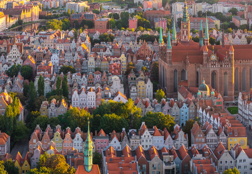Aerial view of the historic city center featuring St. Mary s Church dense colorful rooftops and narrow streets bathed in golden hour light in Gdansk Pomeranian Voivodeship Poland. Aerial view of the historic city center featuring St. Mary s Church dense colorful rooftops and narrow streets bathed in golden hour light in Gdansk Pomeranian Voivodeship Poland.