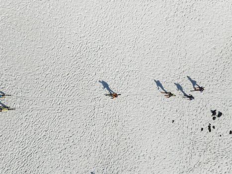Aerial view of people walking on the snowy slopes of the south side of Mount Etna with long shadows on the white surface Nicolosi Sicilia Italy. Aerial view of people walking on the snowy slopes of the south side of Mount Etna with long shadows on the white surface Nicolosi Sicilia Italy.