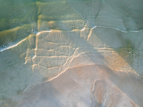 Aerial view of the shoreline where the turquoise water meets the light sand creating a mesmerizing contrast of colors and textures Pantai Tanjung Aan West Nusa Tenggara Indonesia. Aerial view of the shoreline where the turquoise water meets the light sand creating a mesmerizing contrast of colors and textures Pantai Tanjung Aan West Nusa Tenggara Indonesia.