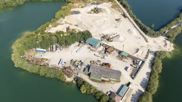 Aerial view of Extraccion de aridos Lima S.L industrial site with heavy machinery piles of gravel and storage buildings in Vilarino das Poldras Ourense Spain. Aerial view of Extraccion de aridos Lima S.L industrial site with heavy machinery piles of gravel and storage buildings in Vilarino das Poldras Ourense Spain.