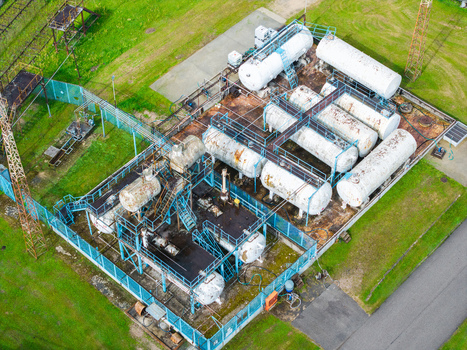 Aerial view of industrial storage tanks at a facility surrounded by green grass and metal fencing in Olaine Olaine Municipality Latvia. Aerial view of industrial storage tanks at a facility surrounded by green grass and metal fencing in Olaine Olaine Municipality Latvia.