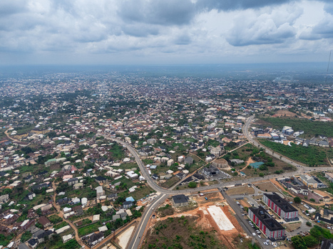 Aerial view of a sprawling cityscape under a cloudy sky where roads intersect amidst buildings and lush greenery Umuahia Abia Nigeria. Aerial view of a sprawling cityscape under a cloudy sky where roads intersect amidst buildings and lush greenery Umuahia Abia Nigeria.