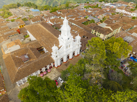 Aerial view of the Immaculate Conception Cathedral stands gleaming white against the backdrop of terracotta roofs and verdant foliage Salamina Caldas Colombia.