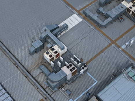 Aerial view of HVAC units and ventilation systems installed on a large corrugated metal industrial rooftop in Melbourne VIC Australia.