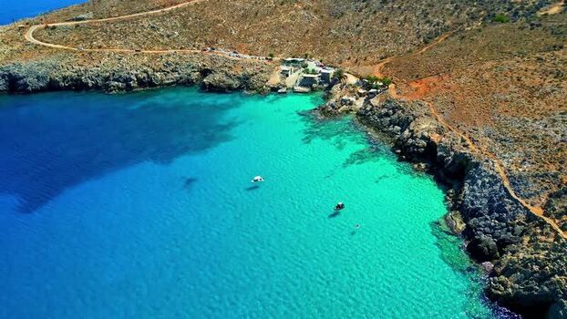 Aerial view of turquoise bay in Crete with boats Greece.