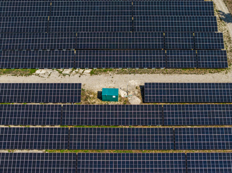 Aerial view of the Solarfeld solar farm with rows of photovoltaic panels and a small green utility box in Hombourg Grand Est France.