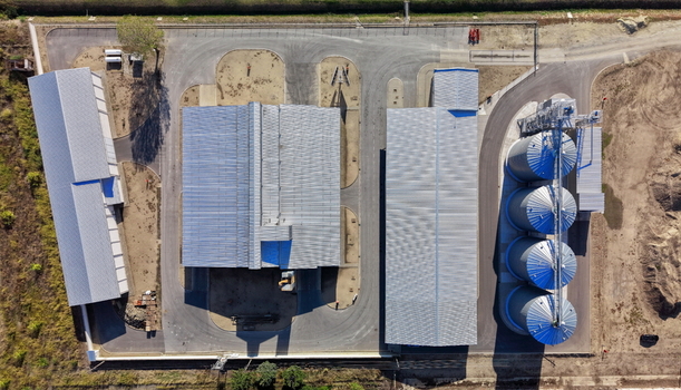 Aerial view of the storage silo Bavaniste facility featuring large metal grain silos and industrial warehouses with corrugated roofs in Bavaniste Vojvodina Serbia.