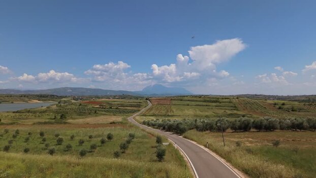 Aerial view of a winding road through rural fields Albania.
