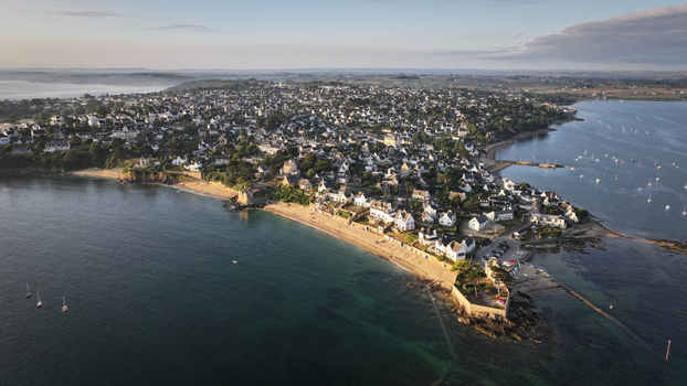 Aerial view of the coastline with its sandy beaches meeting the serene waters dotted with boats surrounded by a charming town Carantec Brittany France. Aerial view of the coastline with its sandy beaches meeting the serene waters dotted with boats surrounded by a charming town Carantec Brittany France.