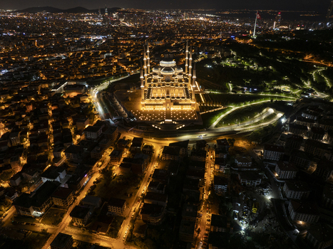 Aerial view of the illuminated Grand Camlica Mosque at night surrounded by the dense urban landscape and glowing city lights in Uskudar Istanbul Turkiye. Aerial view of the illuminated Grand Camlica Mosque at night surrounded by the dense urban landscape and glowing city lights in Uskudar Istanbul Turkiye.