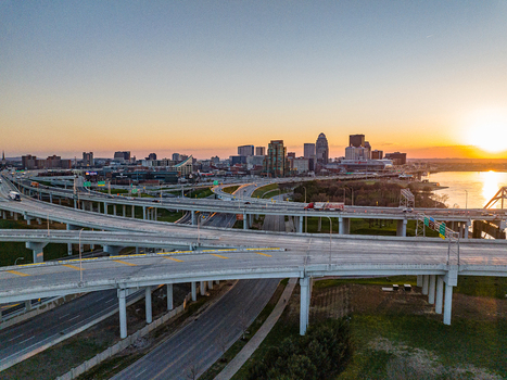 Aerial view of the complex highway interchange and city skyline at sunset with the river in the background in Louisville Kentucky United States.