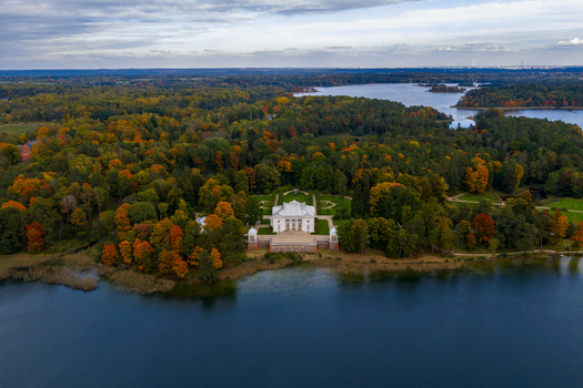 Aerial view of Uzutrakis Manor surrounded by colorful autumn forest on the shore of Lake Galve Trakai Vilniaus apskritis Lithuania.