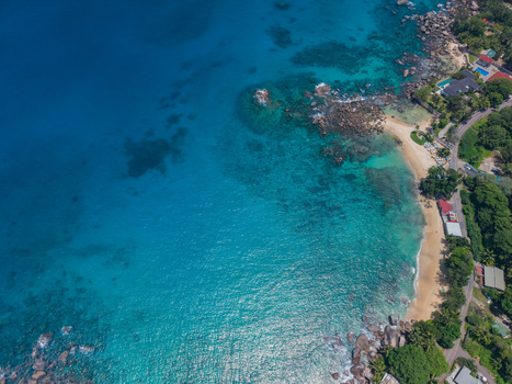 Aerial view of turquoise waters meet the sandy shore with rocky outcrops and lush greenery Vista do Mar Mahe island Seychelles. Aerial view of turquoise waters meet the sandy shore with rocky outcrops and lush greenery Vista do Mar Mahe island Seychelles.