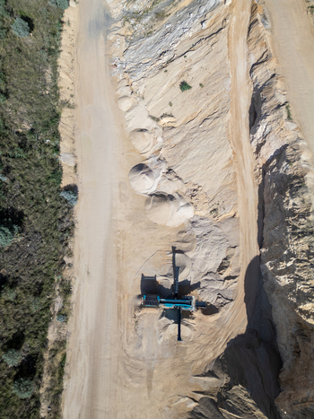 Aerial view of a quarry site with heavy machinery piles of sand and gravel and exposed earth in Teulada Valencian Community Spain.