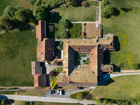 Aerial view of Monastere de Montorge featuring historic red tiled roofs a central courtyard and lush green gardens in Fribourg Fribourg Switzerland.