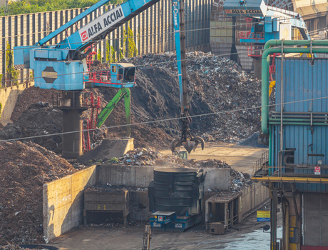 Brescia Italy 13 September 2026 Aerial view of scrap metal handling cranes and recycling operations at the Alfa Acciai steel production plant with large piles of metal waste.