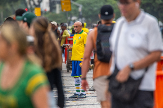 Rio de Janeiro Brazil 13 June 2026 View of a football fan wearing a yellow Brazil national team jersey standing among a crowd on a patterned sidewalk during the World Cup 2026.