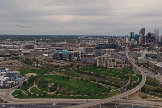 Aerial view of the Denver skyline with its modern skyscrapers urban parkland winding highways and surrounding city infrastructure in Denver Colorado United States. Aerial view of the Denver skyline with its modern skyscrapers urban parkland winding highways and surrounding city infrastructure in Denver Colorado United States.