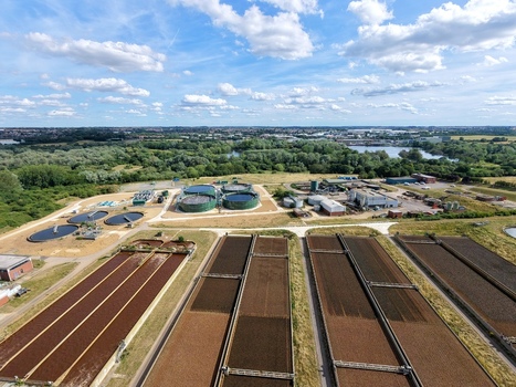 Aerial view of Broadholme water recycling centre featuring large rectangular treatment tanks and circular sedimentation basins surrounded by lush greenery in Rushden England United Kingdom. Aerial view of Broadholme water recycling centre featuring large rectangular treatment tanks and circular sedimentation basins surrounded by lush greenery in Rushden England United Kingdom.