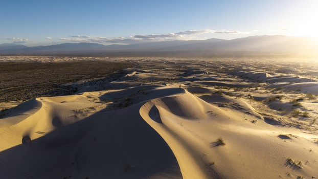 Aerial view of Dunas de Taton featuring vast golden sand dunes under the warm light of the setting sun in Tinogasta Department Catamarca Province Argentina. Aerial view of Dunas de Taton featuring vast golden sand dunes under the warm light of the setting sun in Tinogasta Department Catamarca Province Argentina.