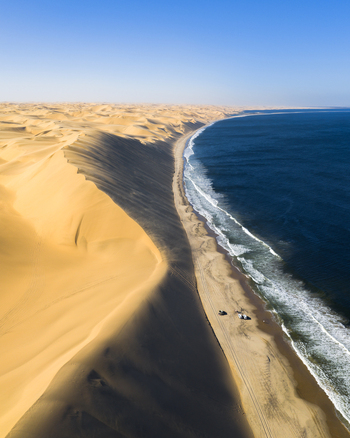 Aerial view of the meeting of the stark golden desert and the deep blue sea where waves crash onto the sandy shore Anichab Erongo Namibia. Aerial view of the meeting of the stark golden desert and the deep blue sea where waves crash onto the sandy shore Anichab Erongo Namibia.