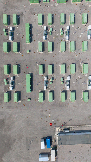 Aerial view of a modern Battery Energy Storage System BESS installation with rows of green energy storage containers and electrical infrastructure in Tavazzano con Villavesco Lombardy Italy.