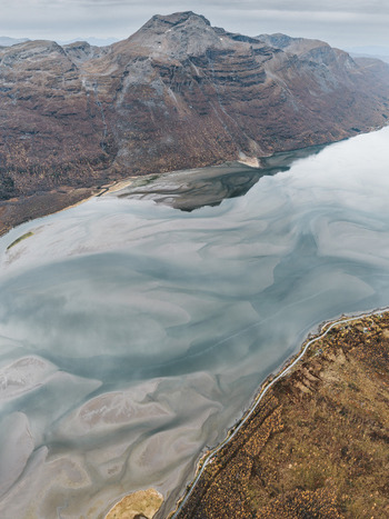 Aerial view of the tidal flats and rugged mountains of Senja Troms Norway.