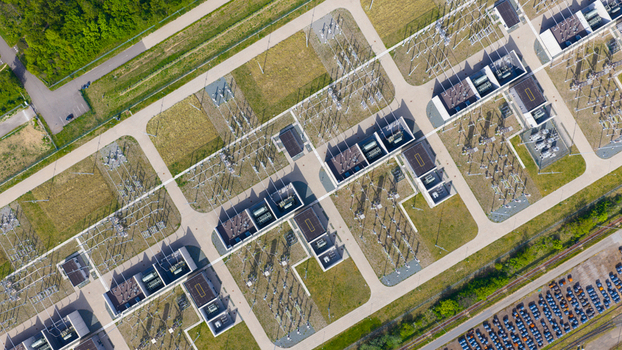 Aerial view of an electrical substation with high voltage transformers and power grid infrastructure surrounded by green trees and a parking lot Velsen Noord North Holland Netherlands.