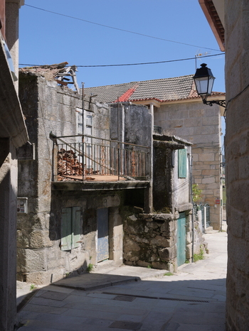 View of a narrow stone street with historic buildings a rustic balcony and traditional architecture in Combarro Pontevedra Spain.