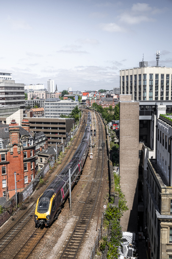 Aerial view of a passenger train traveling along the railway tracks through the urban cityscape of Newcastle upon Tyne England United Kingdom. Aerial view of a passenger train traveling along the railway tracks through the urban cityscape of Newcastle upon Tyne England United Kingdom.