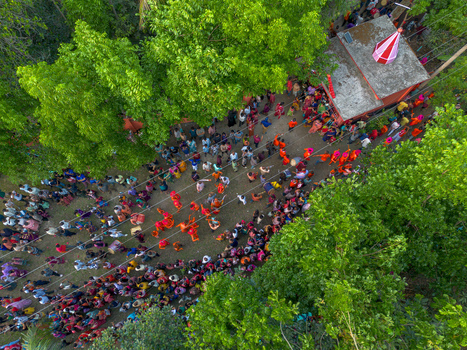 Munshiganj Bangladesh 13 April 2026 Aerial view of a vibrant gathering near a small temple its red and white flag a stark contrast to the surrounding lush greenery.