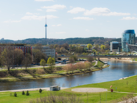 Aerial view of the Neris River flowing through Vilnius with the Vilnius TV Tower in the distance modern architecture and green riverbanks in Vilnius Vilniaus apskritis Lithuania. Aerial view of the Neris River flowing through Vilnius with the Vilnius TV Tower in the distance modern architecture and green riverbanks in Vilnius Vilniaus apskritis Lithuania.