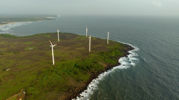 Aerial view of the Devgad Windmills standing on a lush green coastal cliff overlooking the Arabian Sea in Devgad Maharashtra India. Aerial view of the Devgad Windmills standing on a lush green coastal cliff overlooking the Arabian Sea in Devgad Maharashtra India.