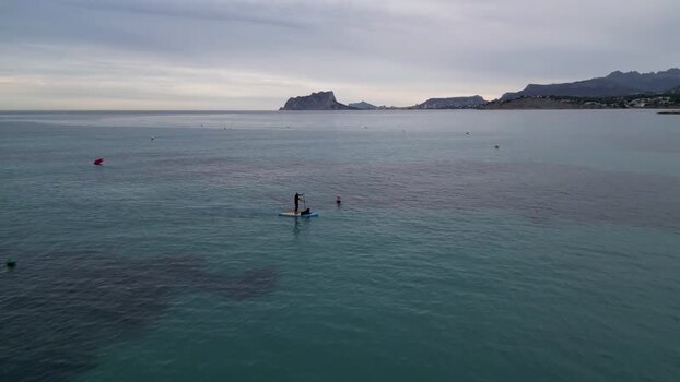 Aerial view of paddleboarder near Penon de Ifach Spain.