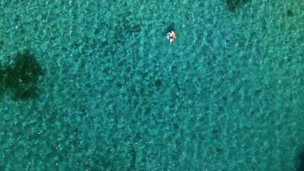 Aerial view of a person floating in turquoise tropical water Honduras. Aerial view of a person floating in turquoise tropical water Honduras.