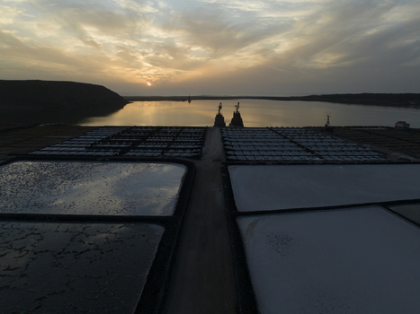 Aerial view of Salinas de Janubio salt pans at sunset with calm water reflecting the golden sky and geometric patterns of the salt fields in Las Palmas Canarias Spain. Aerial view of Salinas de Janubio salt pans at sunset with calm water reflecting the golden sky and geometric patterns of the salt fields in Las Palmas Canarias Spain.