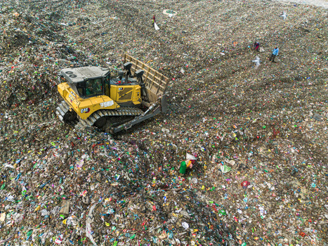 Aminbazar Bangladesh 26 January 2025 Aerial view of a yellow bulldozer moving piles of plastic waste and garbage at the Aminbazar landfill with waste pickers working on the site. Aminbazar Bangladesh 26 January 2025 Aerial view of a yellow bulldozer moving piles of plastic waste and garbage at the Aminbazar landfill with waste pickers working on the site.