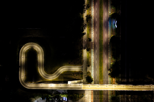 Aerial view of the illuminated Hilde Archenhold Brucke pedestrian bridge at night featuring its distinctive curved path and surrounding trees in Berlin Berlin Germany. Aerial view of the illuminated Hilde Archenhold Brucke pedestrian bridge at night featuring its distinctive curved path and surrounding trees in Berlin Berlin Germany.