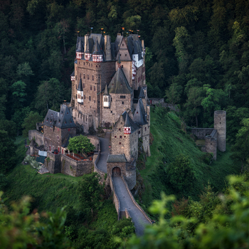 Aerial view of Eltz Castle surrounded by dense forest and lush greenery in Germany.
