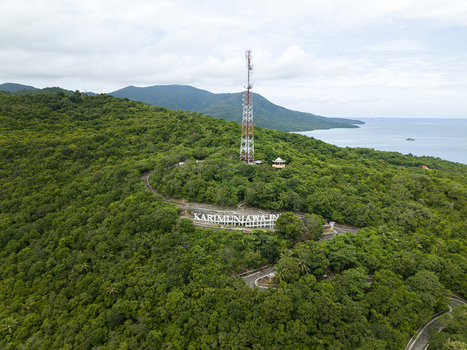 Aerial view of the verdant landscape crowned by a towering telecommunications mast overlooking the tranquil sea Karimunjawa Central Java Indonesia. Aerial view of the verdant landscape crowned by a towering telecommunications mast overlooking the tranquil sea Karimunjawa Central Java Indonesia.