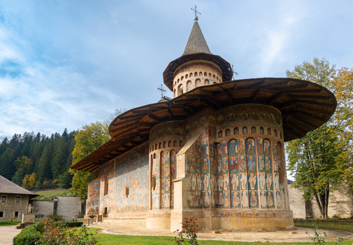 View of the historic Voronet Monastery featuring intricate exterior frescoes and traditional architecture in Voronet Judetul Suceava Romania. View of the historic Voronet Monastery featuring intricate exterior frescoes and traditional architecture in Voronet Judetul Suceava Romania.