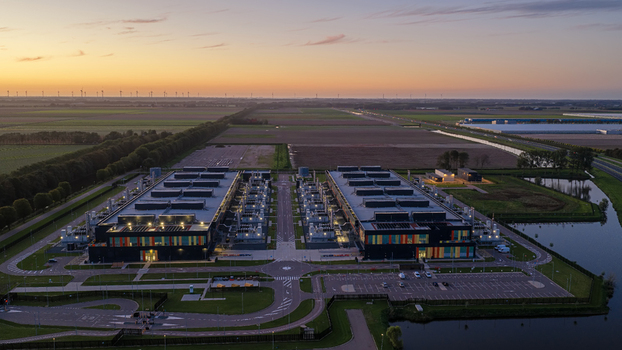 Aerial view of the Microsoft Data Center surrounded by agricultural fields and wind turbines at sunset in Middenmeer North Holland Netherlands. Aerial view of the Microsoft Data Center surrounded by agricultural fields and wind turbines at sunset in Middenmeer North Holland Netherlands.