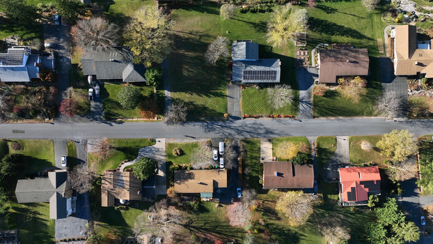 Aerial view of suburban houses with driveways green lawns and autumn trees in a residential neighborhood in Harrisonburg Virginia United States.