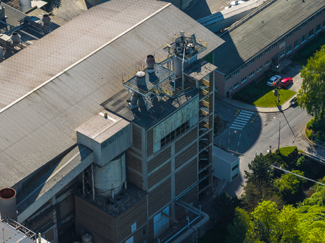 Aerial view of an industrial factory building with metal roofing ventilation systems and pipes located in an urban area of Prague Prague Czechia.